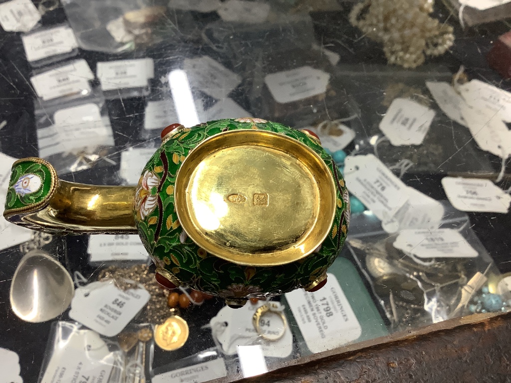 A group of Russian style white metal and enamel items including kovshs, egg pendants and small cups.